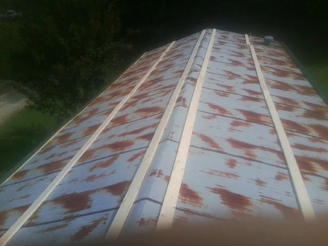 Rusted metal roof panels with new wood purlins before replacement — Storm Damage Roof Repair in Barre by Roofing Brothers