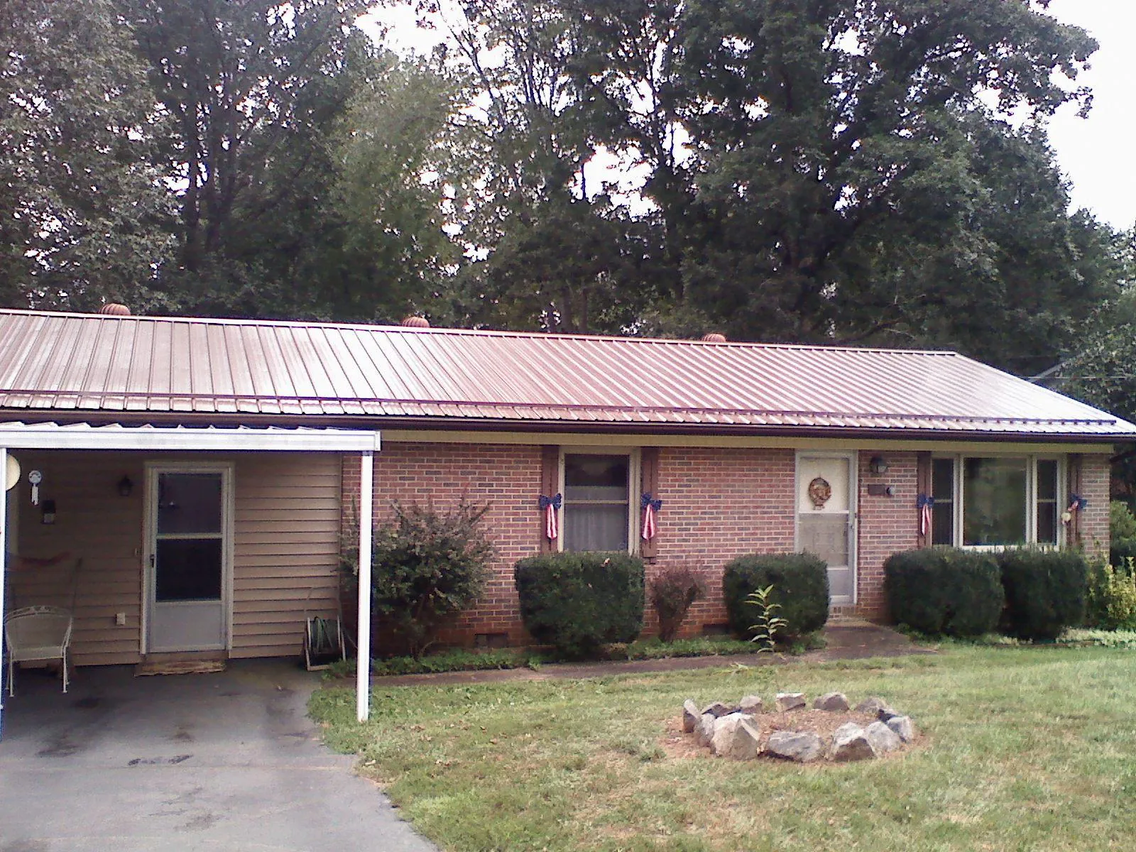 Bronze metal roof and carport on a brick ranch home — Roof Repair work by our crew in Barre